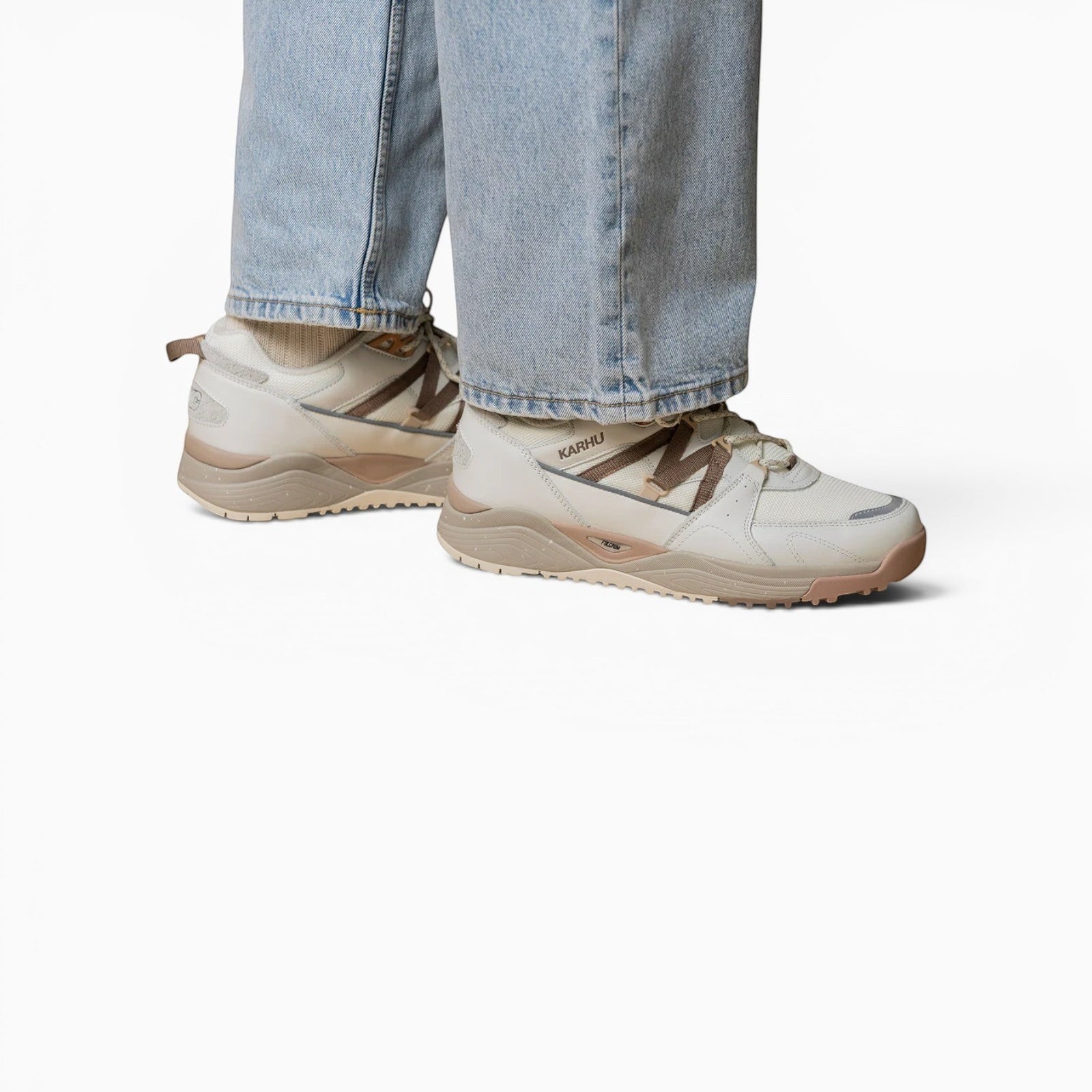 Baskets Karhu Fusion XC blanc cassé et marron portées avec un jean, style outdoor hybride avec semelle technique.